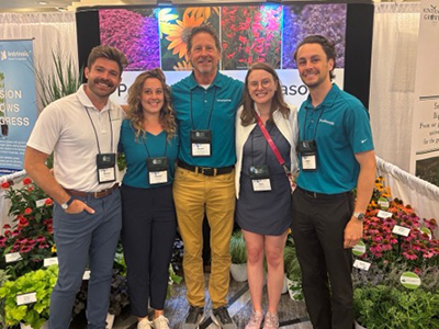 Darwin Perennials Team standing in front of trade show display